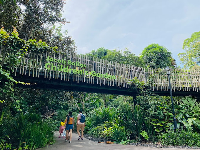 Jacob Ballas Children's Garden entrance area with a sign and a bridge surrounded by plants